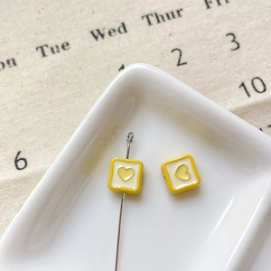 Détail macro de breloques coeur en alliage avec bord jaune pour bijoux DIY