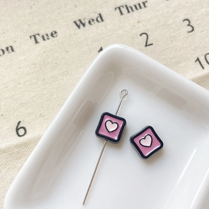 Vue macro de breloques cœur rose avec bord noir pour la création de bijoux DIY créatifs