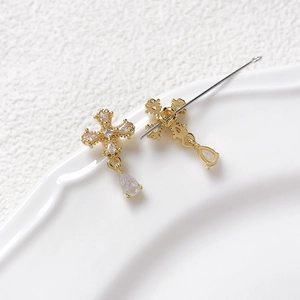 Macro shot of gold-plated cross pendant with shimmering cubic zirconia and pear drop