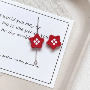 Macro view of a red star button bead with white dots and metal pin for DIY jewelry crafts