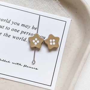 Detailed view of mocha-colored star-shaped beads on a stylish white decorative card