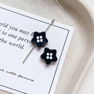 Macro detail of star shaped enamel beads with white polka dots for DIY jewelry making
