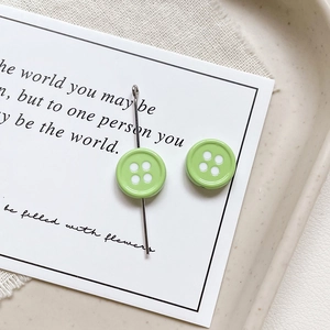 Close-up of light green button-shaped alloy charms for DIY jewelry and phone chains