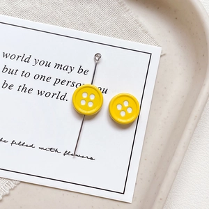 Detailed close-up of bright yellow four-hole button charms for DIY jewelry making