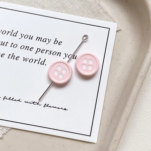 Detailed macro view of pink resin button charms for DIY jewelry making and phone chains