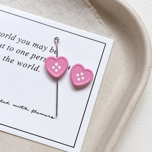 Macro view of pink heart-shaped button beads with four holes and metal pin back