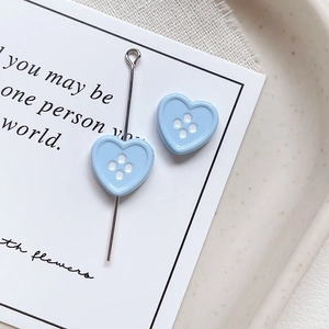 Macro shot of light blue heart-shaped button beads with four holes for DIY jewelry