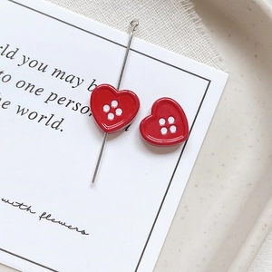 Close-up of red heart button charms with glossy enamel finish for DIY jewelry