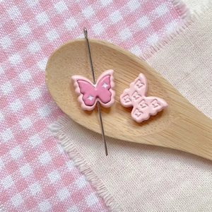 Detailed view of pink butterfly resin beads with hole for DIY jewelry making and crafts