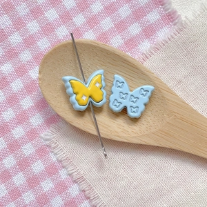 Macro detail of butterfly DIY beads with floral paint and embossed resin texture