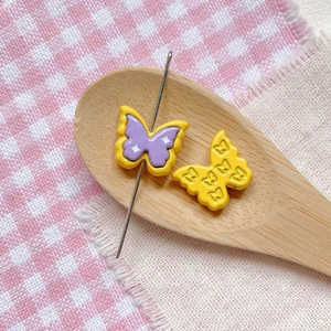 Macro shot of colorful butterfly beads in a wooden spoon for DIY jewelry making