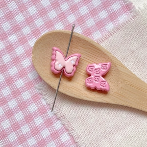 Close-up of pink butterfly resin beads with polka dots and patterns for DIY jewelry making