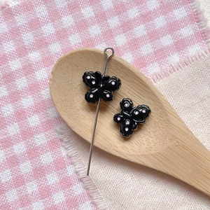 Macro detail of a black butterfly bead with pink dots for DIY jewelry making