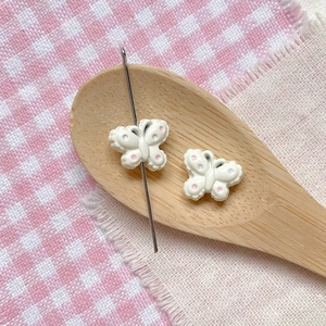 Close-up of cream butterfly bead with pink polka dots for DIY jewelry making