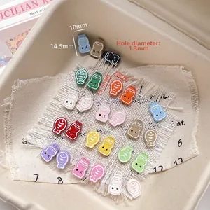 Vue macro de breloques colorées en résine en forme de biberon et de poisson pour DIY