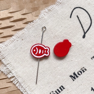 Détails macro de breloques en alliage de poisson rouge avec motifs blancs pour bijoux DIY