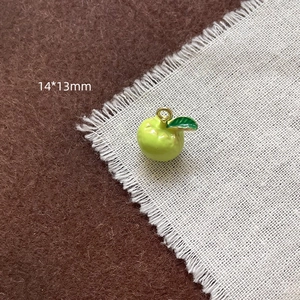 Détail du pendentif pomme verte émaillée mesurant 14x13mm pour création de bijoux DIY