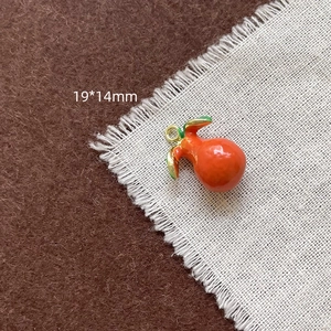 Détail d'une breloque fruit 19x14mm avec feuilles vertes pour la création de bijoux