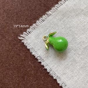 Détail du pendentif poire en émail vert avec feuilles dorées, taille de 19x14mm