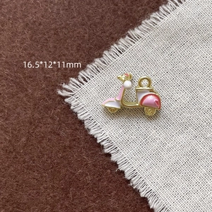 Vue détaillée du pendentif moto en émail rose avec fermoir mousqueton pour bijoux