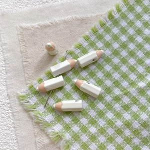 Detail of pencil-shaped beads with metal needles for DIY jewelry making and crafts