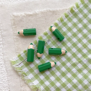 Detailed view of green pencil-shaped alloy beads for DIY jewelry and handmade crafts