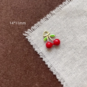 Détail d'un pendentif cerise en émail 14x11mm plaqué or pour la création de bijoux DIY