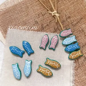 Macro detail of tropical fish shaped beads with colorful stripes for DIY jewelry making