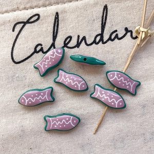 Macro shot of fish-shaped striped alloy beads for DIY jewelry with side hole structure