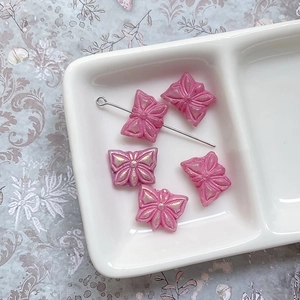 Détail macro de perles papillon en verre rose avec finition nacrée arc-en-ciel