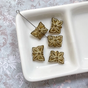 Détail de perles papillon vintage avec accents dorés pour la création de bijoux DIY