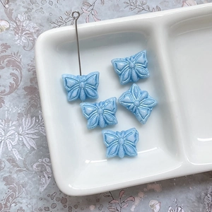 Détail de perles papillon tchèques bleues avec bords dorés pour bijoux DIY