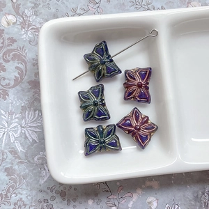 Gros plan de perles papillon en verre tchèque avec bords dorés pour bijoux artisanaux