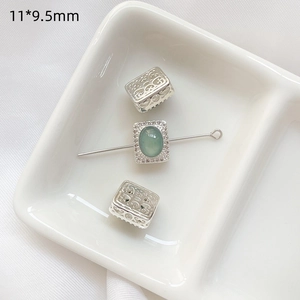 Detalle macro de cuenta hueca de plata S925 y colgante de jade con circonitas