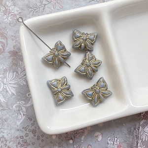 Vue détaillée de perles papillon en verre rétro avec bord doré et détails de perçage