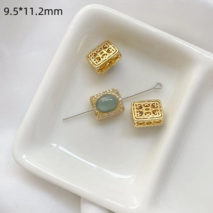 Vista macro de cuentas doradas de 9,5x11,2mm con piedra verde y circón para joyería