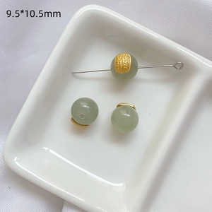 Detalle macro de cuentas de jade verde con tapas doradas grabadas para joyería DIY