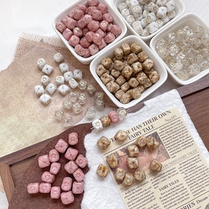 Close-up of vintage cubic glass beads with engraved sun patterns for DIY jewelry making