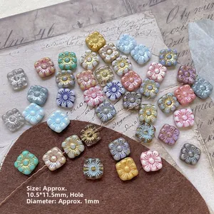 Detail of square flower glass beads with gold accents for DIY jewelry making