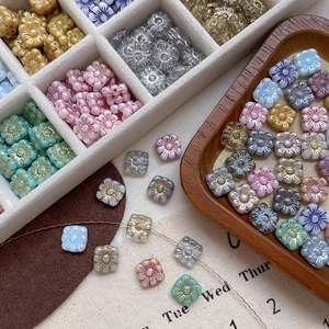 Detailed close-up of colorful Czech glass square flower beads with Picasso gold-painted edges