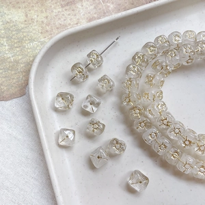 Close-up of Czech glass beads with gold sun pattern for DIY jewelry making