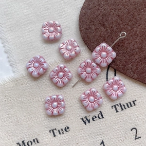 Close-up of pink Czech glass flower beads with pearlescent finish for DIY jewelry