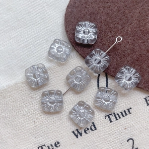 Macro view of square grey Czech glass flower beads with etched Picasso finish detail