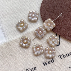 Macro shot of square Czech glass beads with embossed flower pattern for DIY jewelry