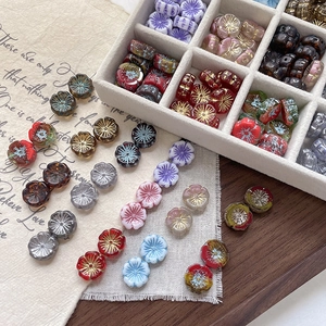 Macro shot of colorful glass flower beads with golden patterns for DIY jewelry making