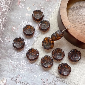 Detailed macro view of amber Czech glass flower beads with gold accents for DIY jewelry