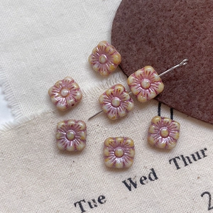 Macro view of vintage square floral Czech glass beads for DIY jewelry making