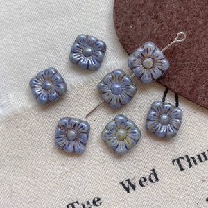 Detailed macro shot of vintage blue square Picasso glass flower beads for DIY jewelry