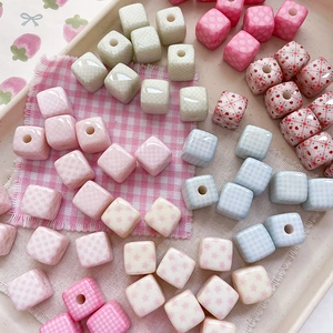 Close-up of pastel macaron-colored cube beads with heart and polka dot patterns