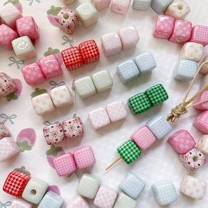 Close-up of cube ceramic beads with plaid, dots, and heart patterns for DIY jewelry